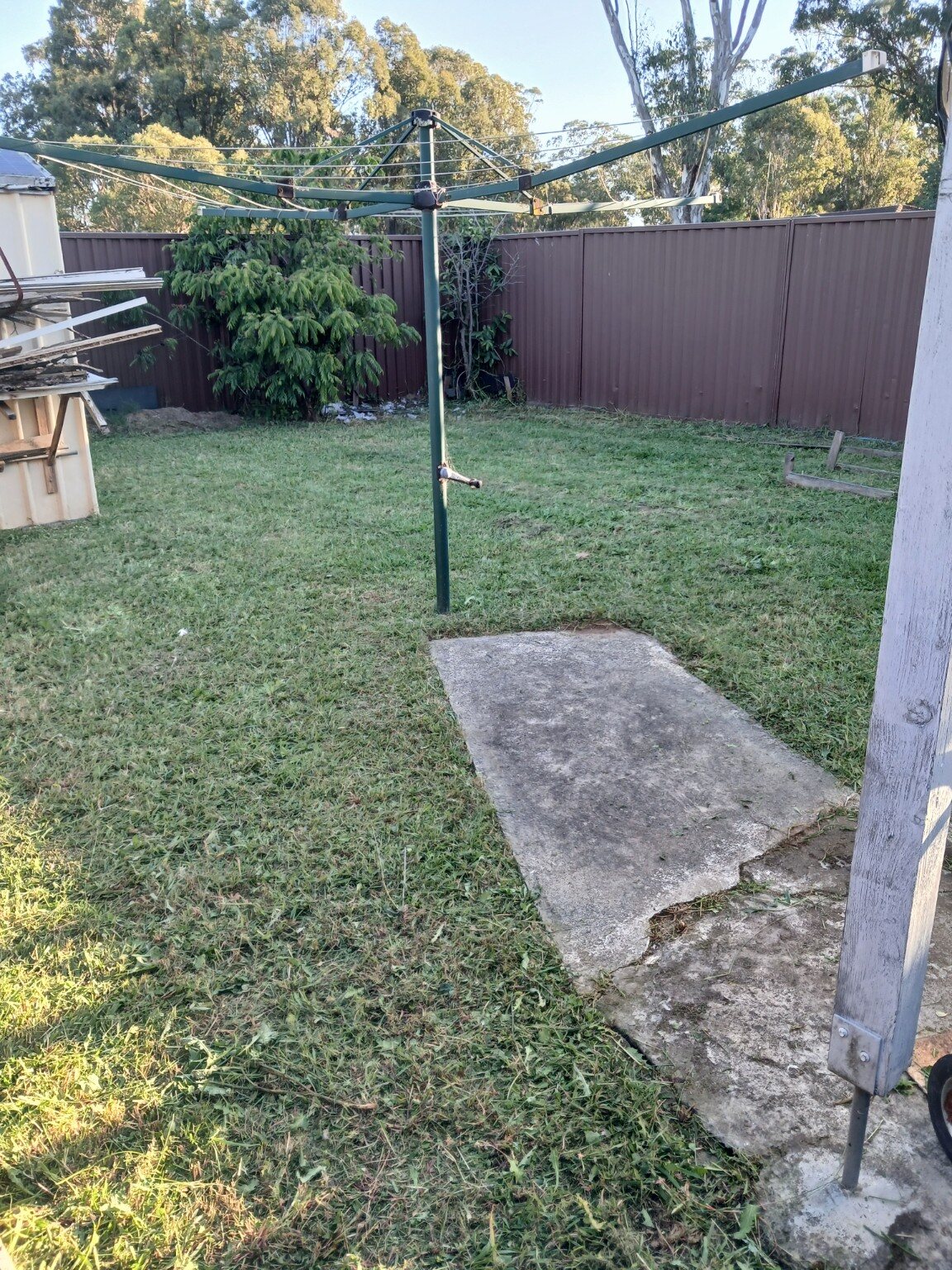 Tidy mowed backyard lawn around a rotary clothesline